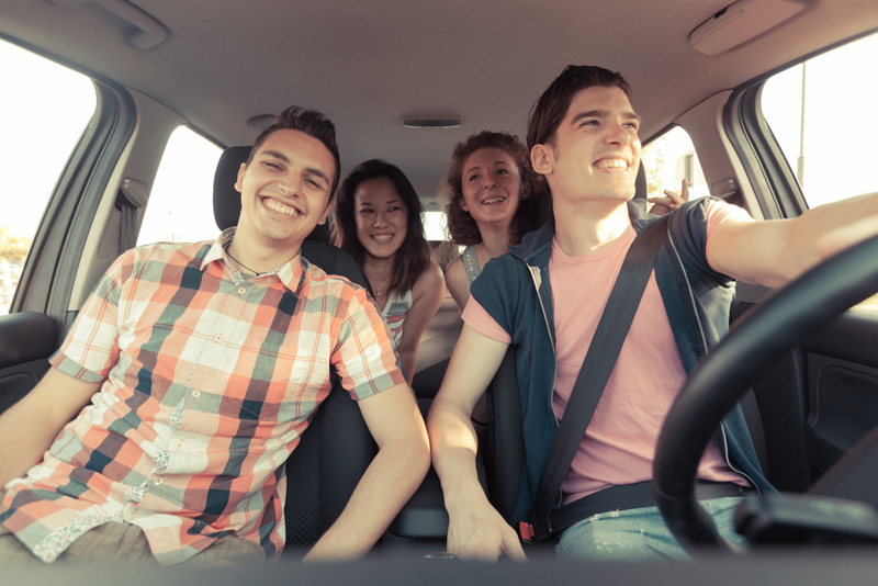 Save money on the road with our handy summer driving tips Four Friends Driving On a Summer Road Trip